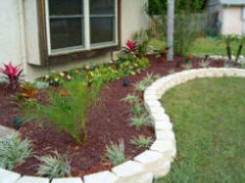 Concrete block edge separates mixed garden border and lawm